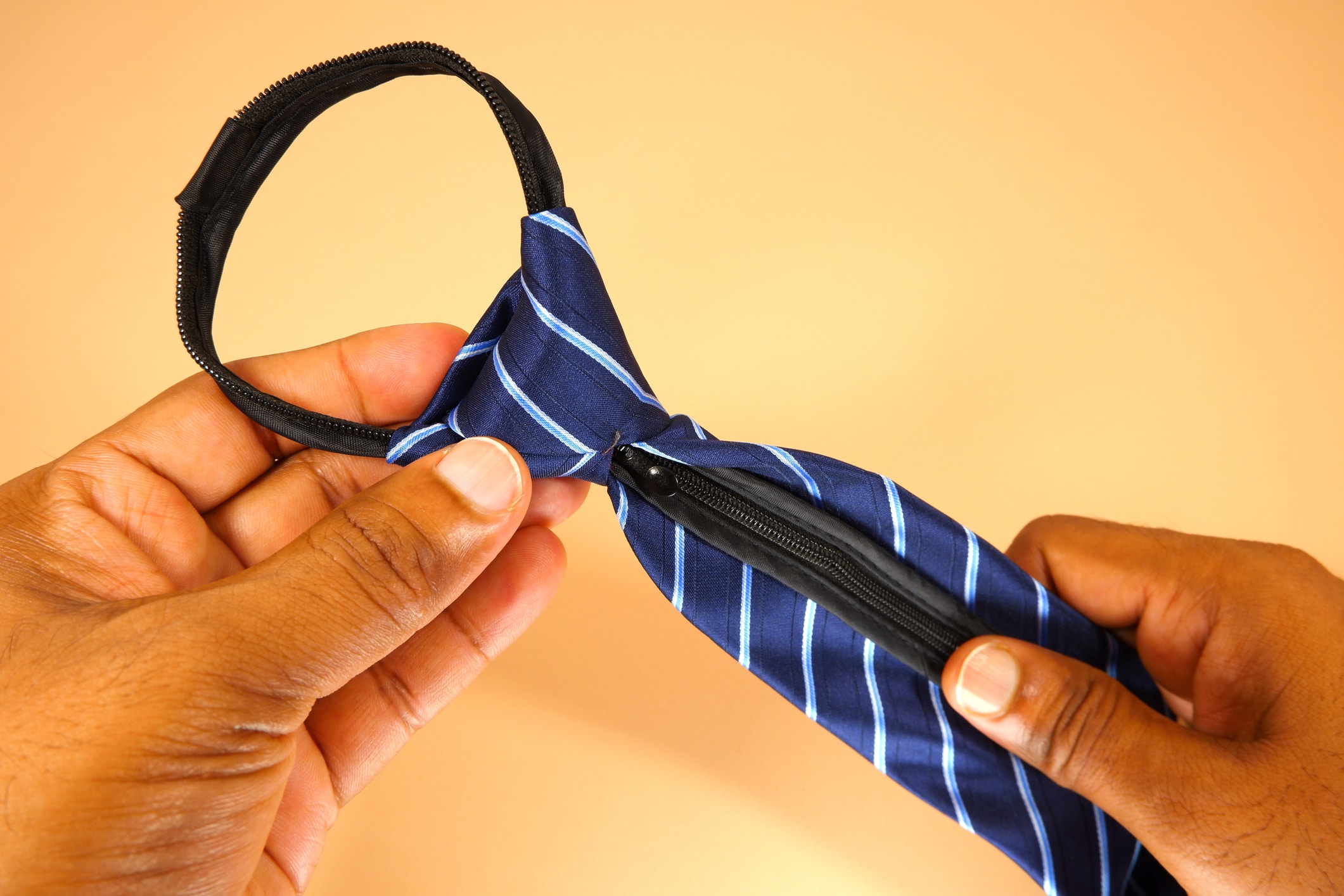 Blue colour polyester fabric necktie holding hand with close up view, hand holding necktie